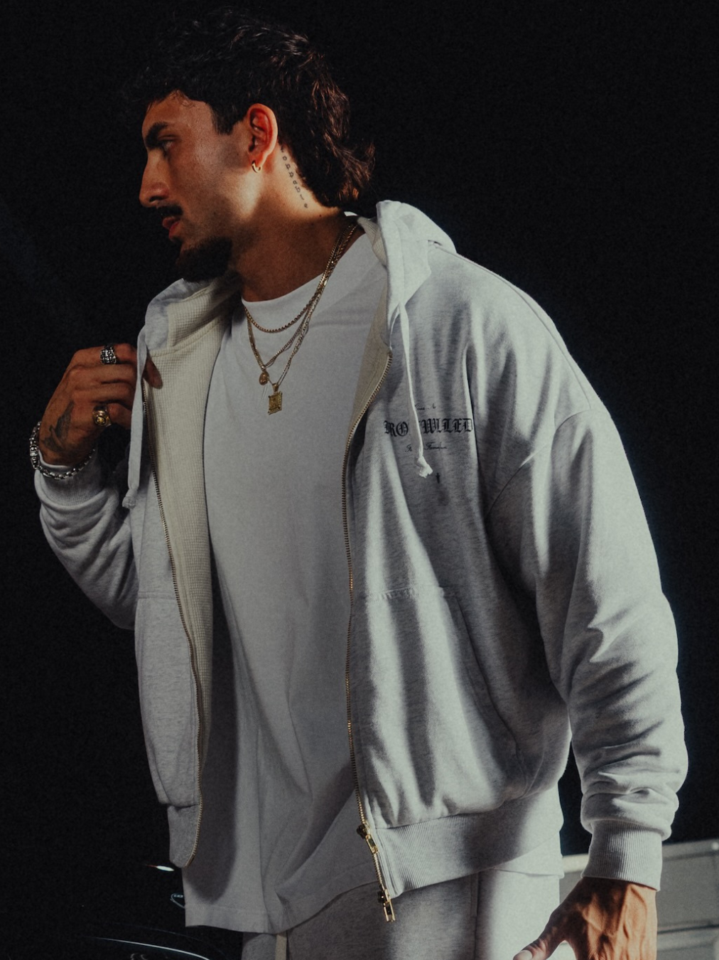 Model wearing the Heritage zip hoodie open over a white tee
