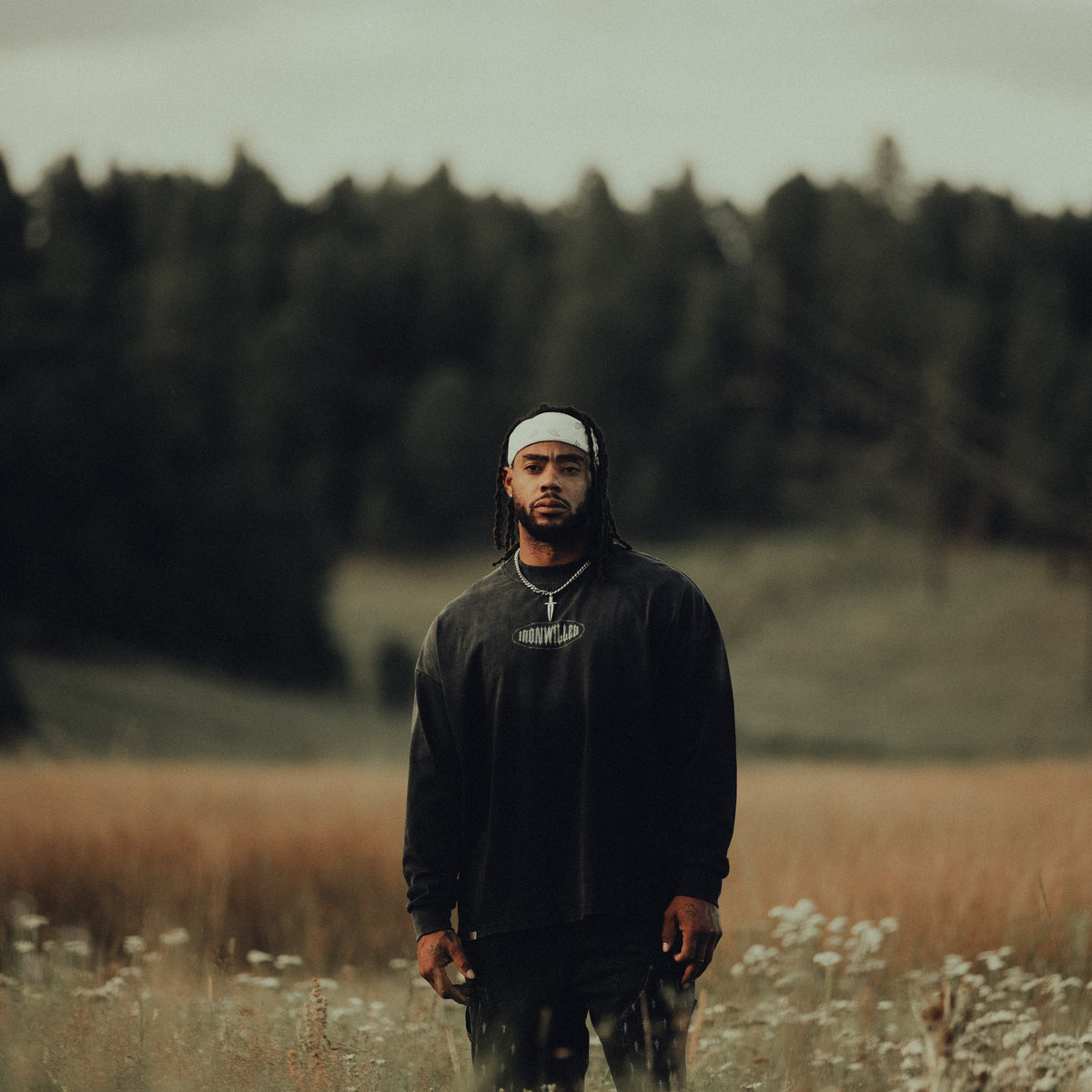 An athlete in the Dead or Alive long sleeve standing in a meadow