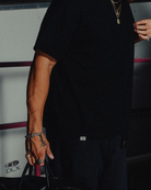 Model in the black classic crew tee, metal tab at the hem