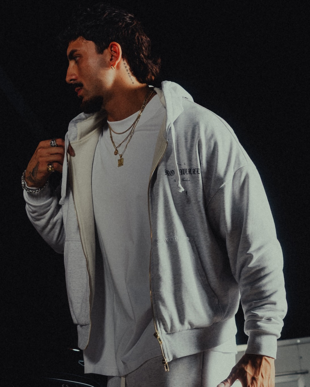 Model wearing the Heritage zip hoodie open over a white tee