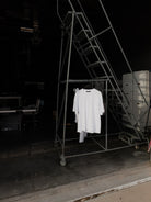White classic crew tee hanging on a rolling rack