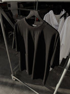 Black classic crew tee on a hanger, dagger embroidery at the neck