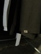 Signature metal tab at the bottom hem of the black tee