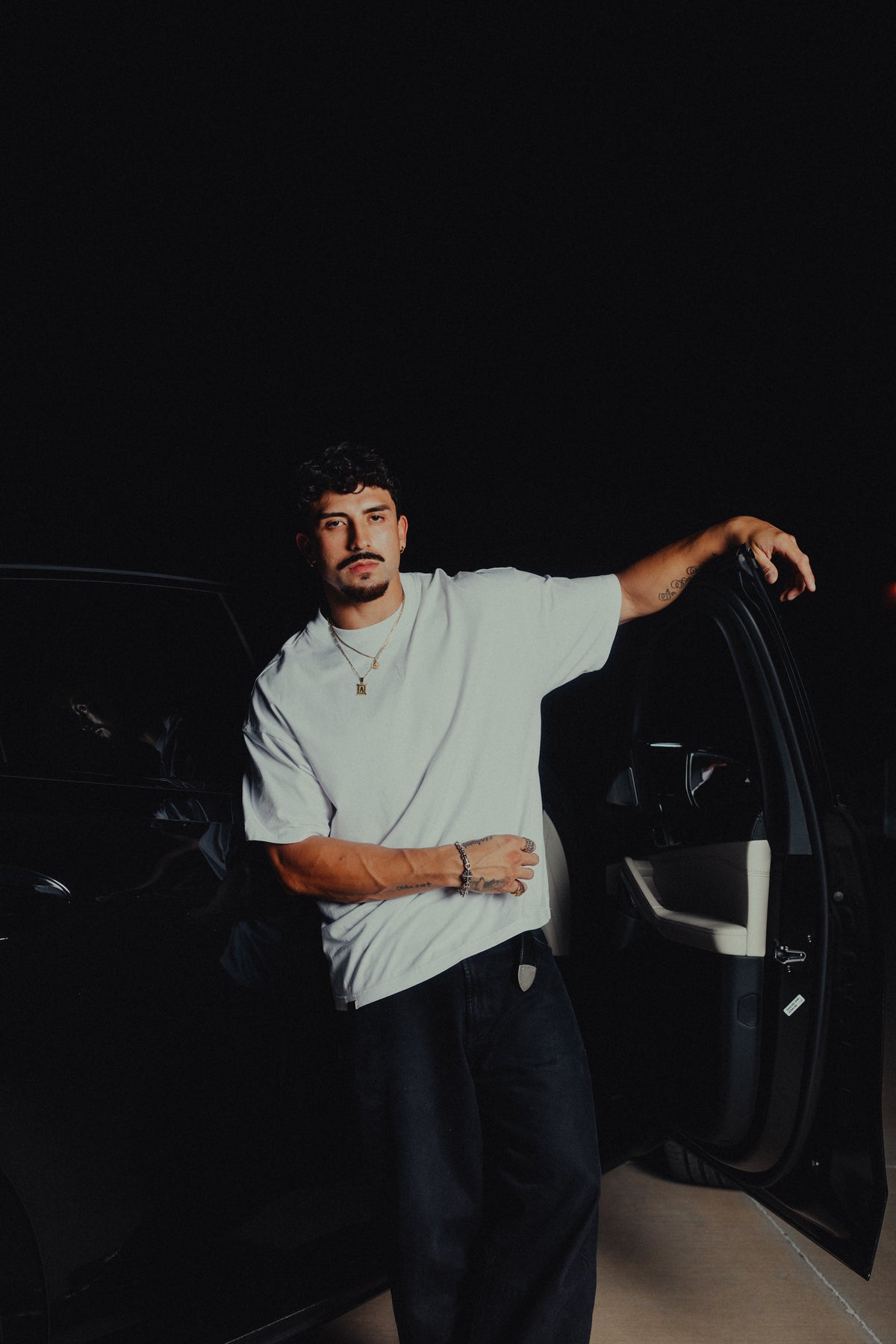 Model leaning on a car door in the white classic crew tee