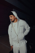 Model wearing the heather grey Heritage zip hoodie with the hood up