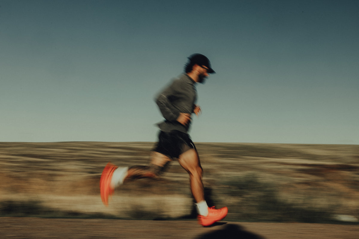 Runner in motion on a desert road at dusk